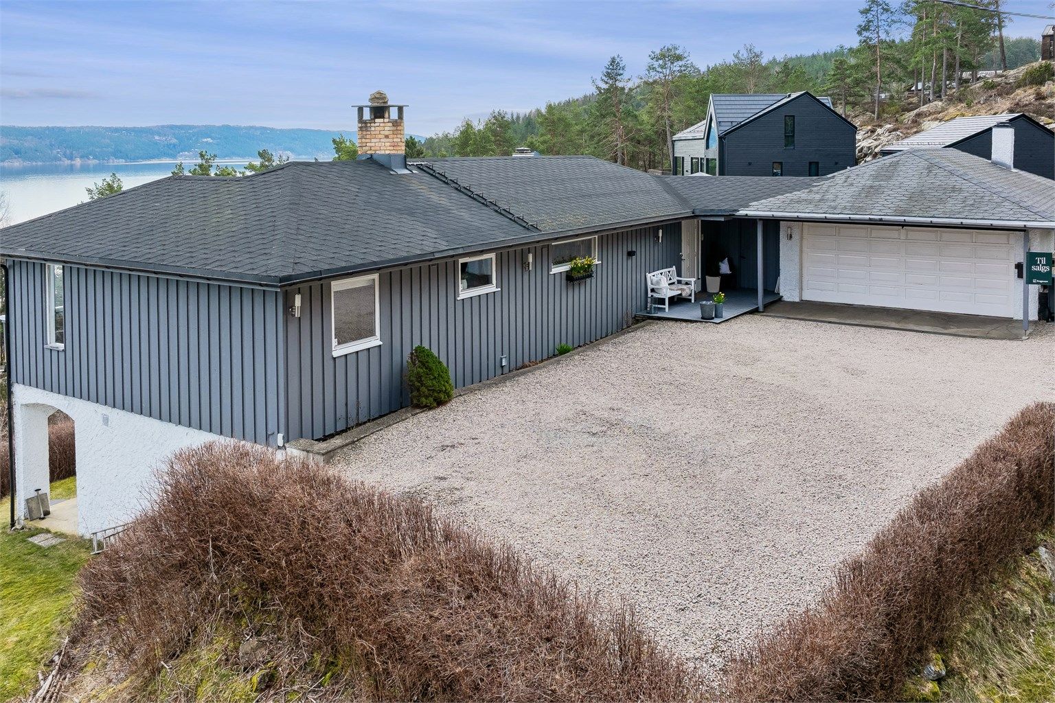 En stor og pent opparbeidet gårdsplass gir eiendommen et innbydende førsteinntrykk, med god plass til parkering, lek og hyggelige uteaktiviteter. Foto: Per O. Skjellnan v/Efkt