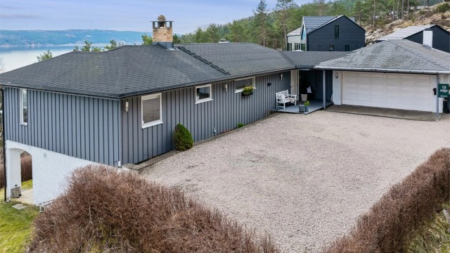 En stor og pent opparbeidet gårdsplass gir eiendommen et innbydende førsteinntrykk, med god plass til parkering, lek og hyggelige uteaktiviteter. Foto: Per O. Skjellnan v/Efkt