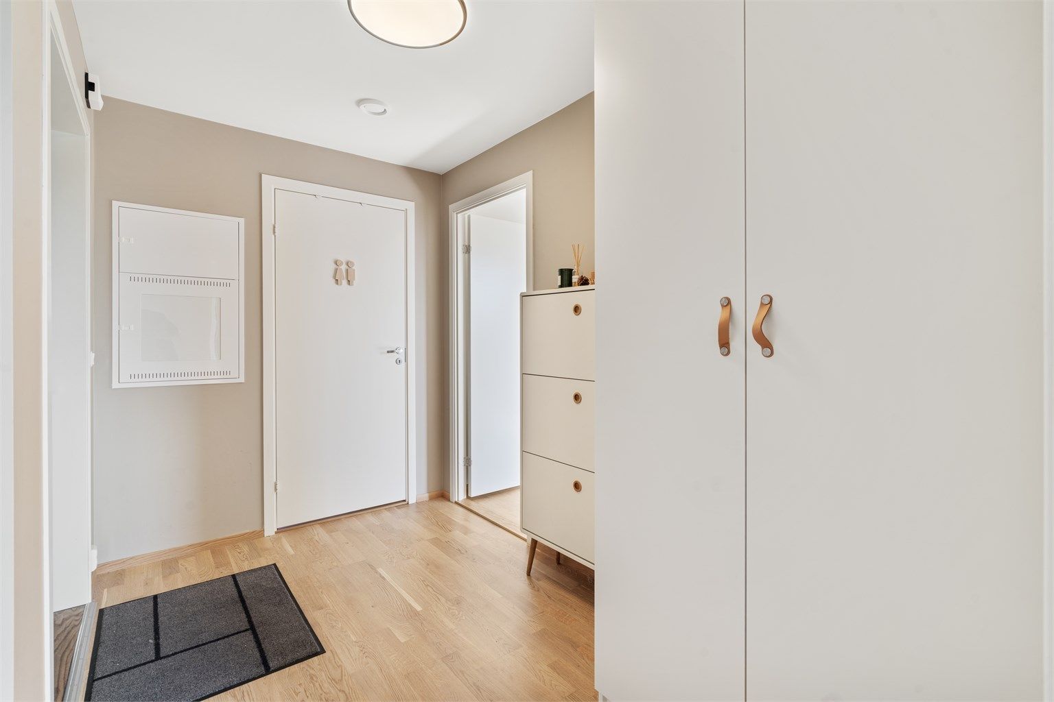 Gjennomgående parkett og malte flater gir et helhetlig og moderne inntrykk.