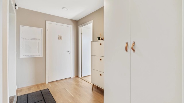 Gjennomgående parkett og malte flater gir et helhetlig og moderne inntrykk.