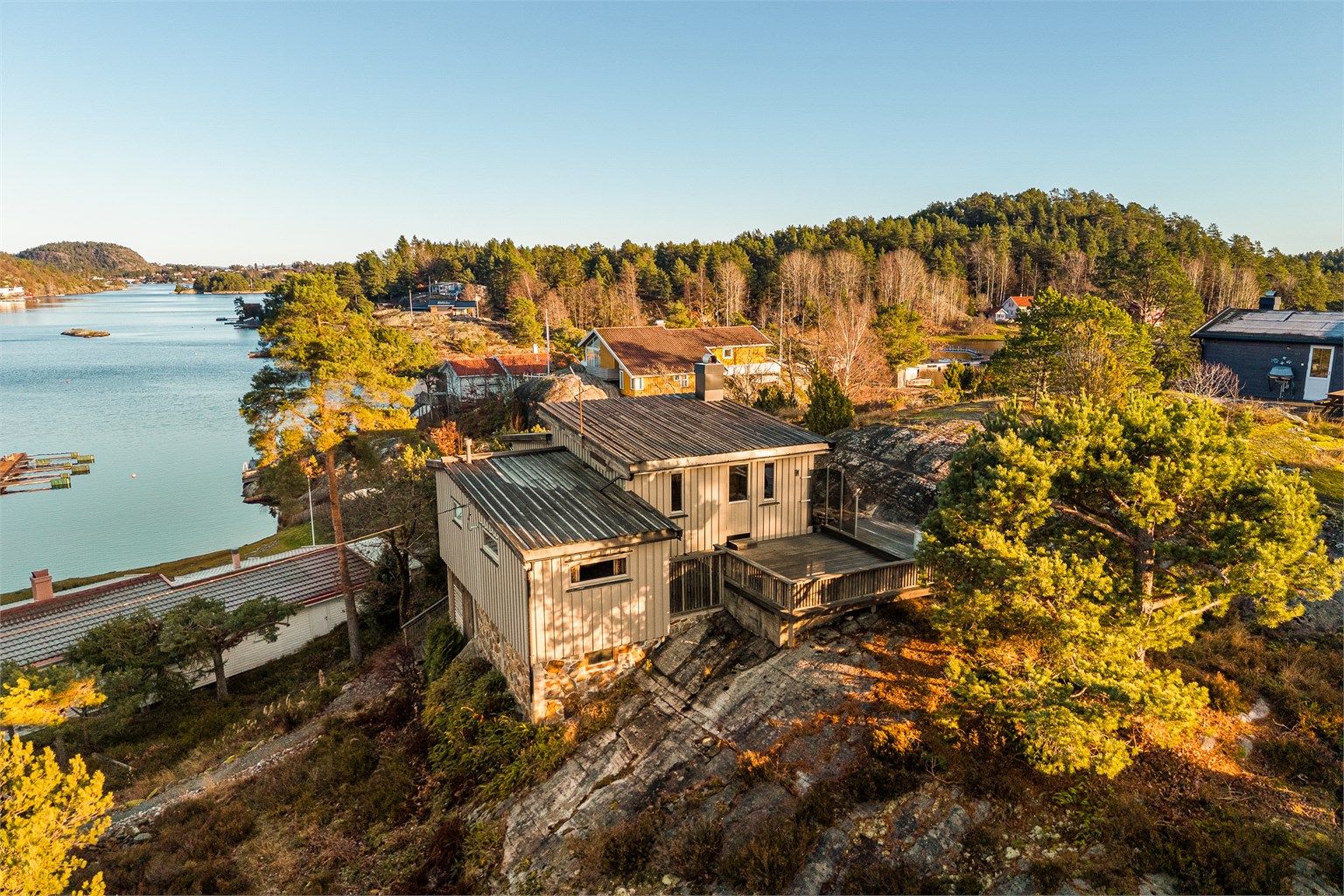 Oversiktsbilde som viser hyttas plassering i forhold til sjøen og nabobebyggelsen.