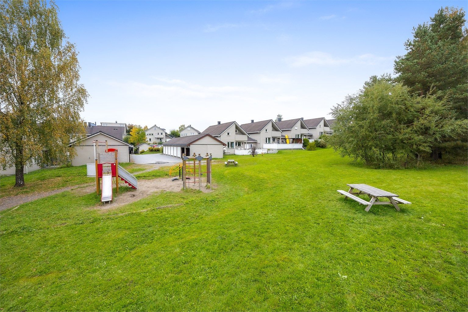 Store, grønne fellesarealer med lekeplass og balløkke rett utenfor.