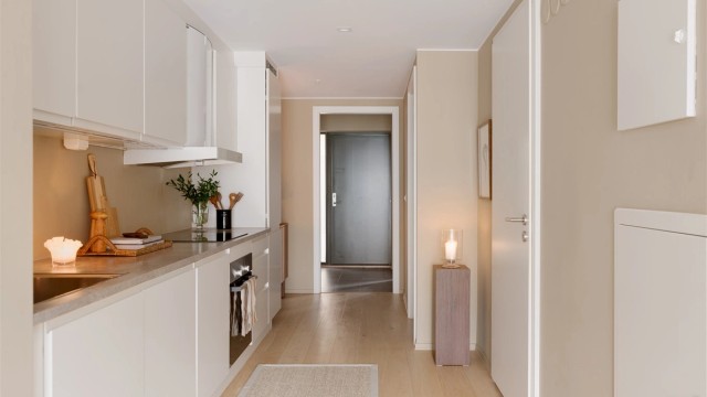 Kjøkkeninnredning med moderne, glatte fronter og laminert benkeplate med nedfelt vask.