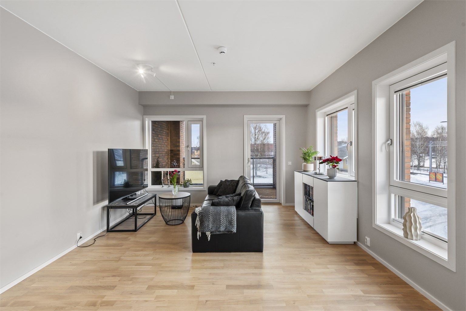 Innbydende stue med store vindusflater og utgang til balkong