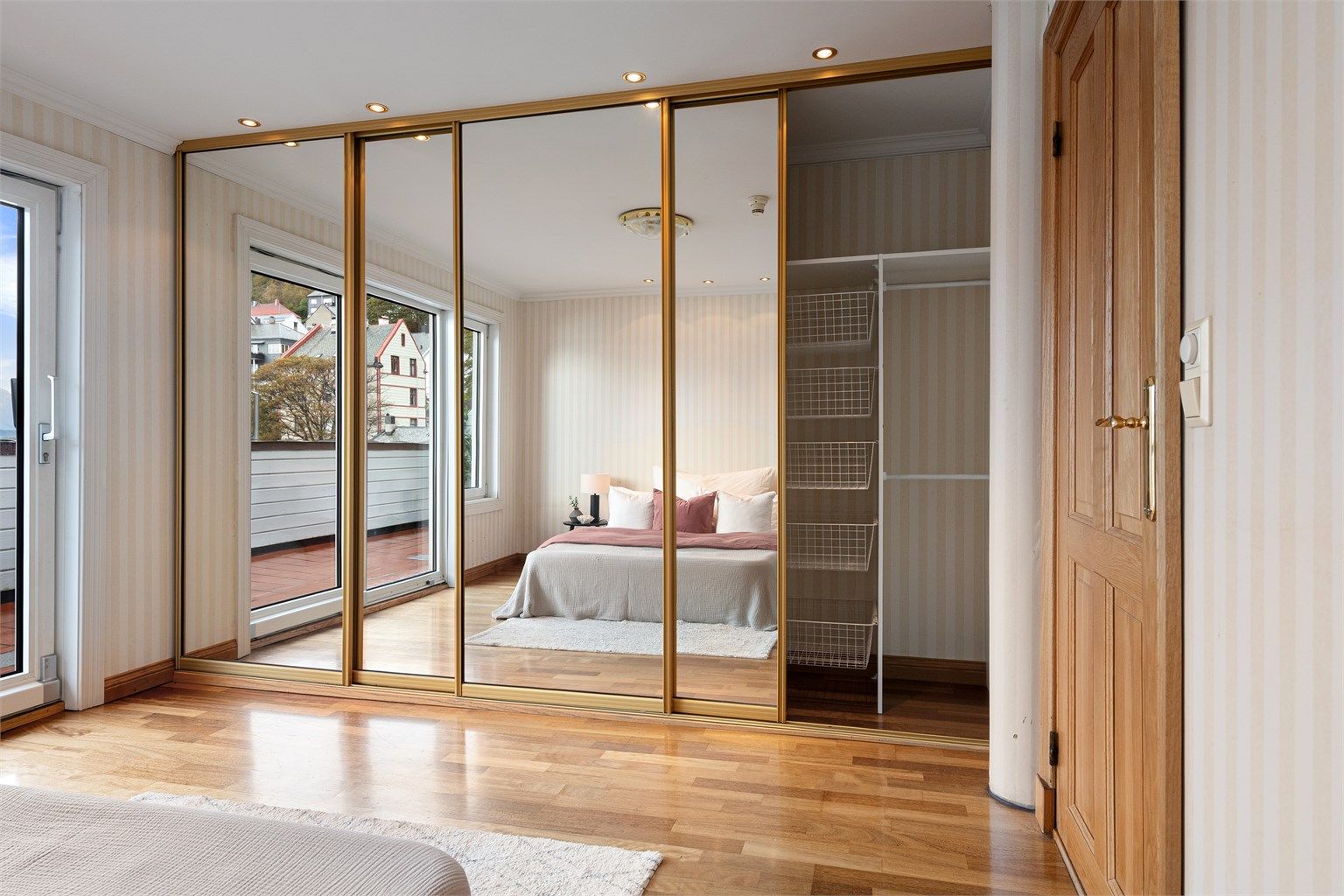 Stor skyvedørsgarderobe med integrert innredning og speilfronter.
