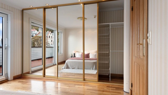 Stor skyvedørsgarderobe med integrert innredning og speilfronter.