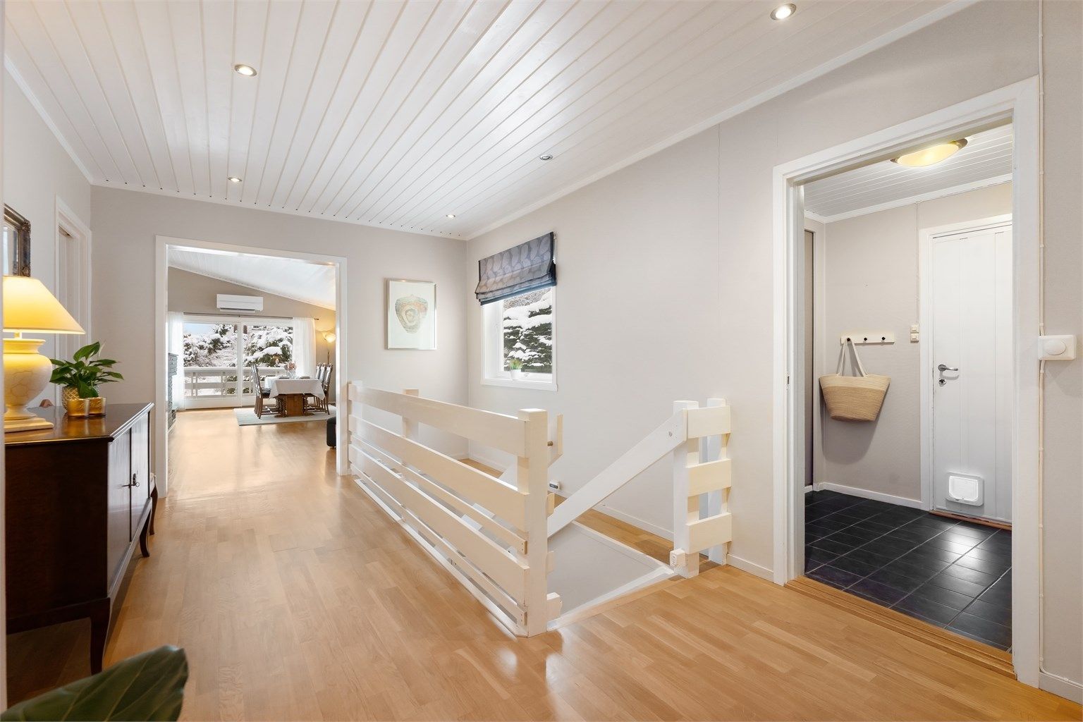 Gangen leder videre inn mot stuen og kjøkkenet, og har trapp ned til underetasjen.