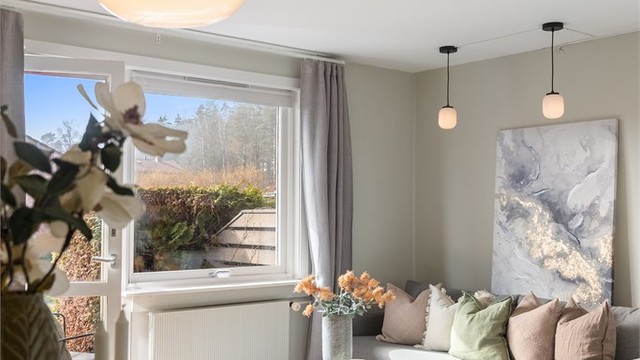 Utsikt fra spiseplassen mot sofakroken og vinduet.