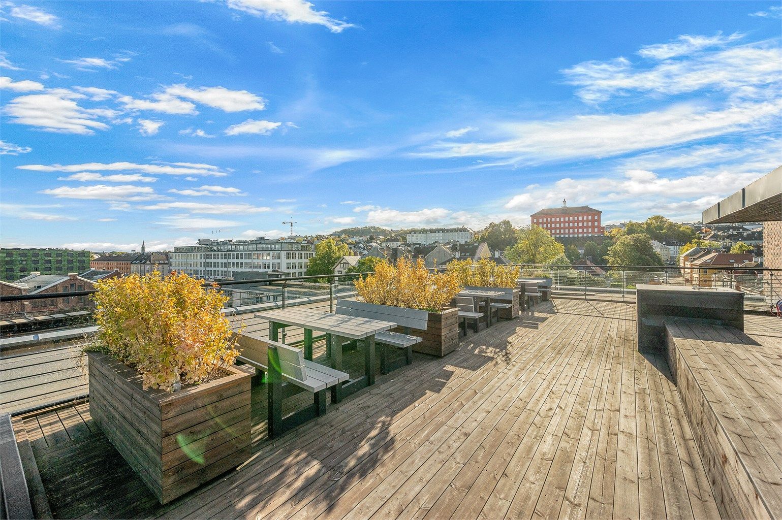 Felles takterrasse med sittegrupper, plantekasser og utsikt mot Kristiansten festning.