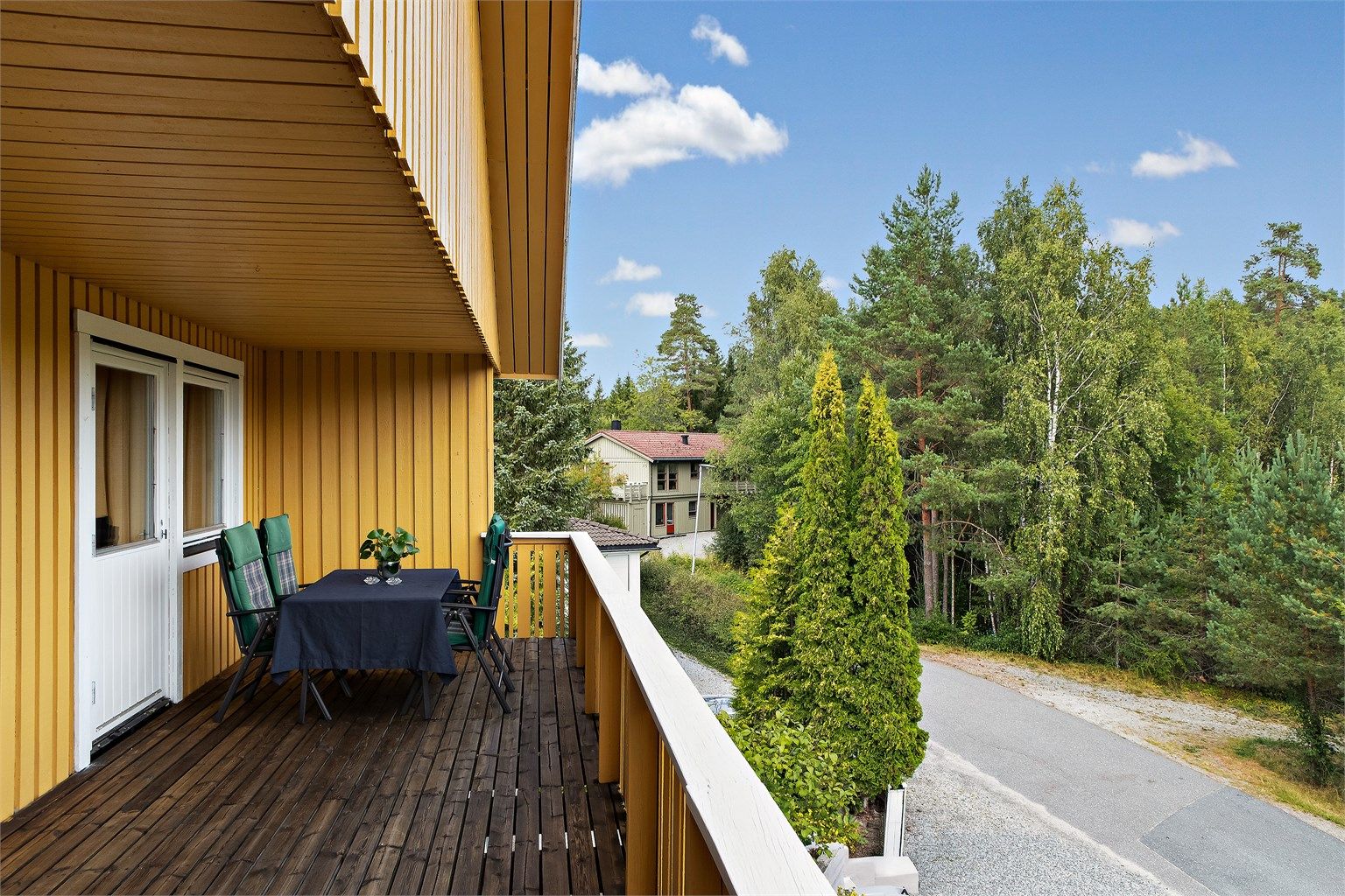 Den overbygde verandaen har god plass til sittegruppe og fint utsyn over nabolaget.
