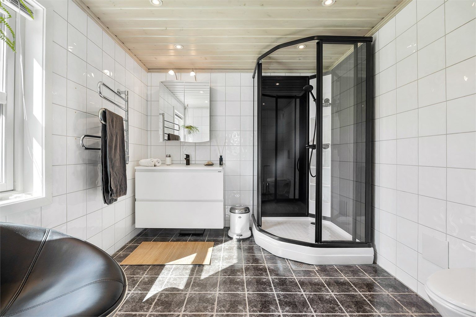 Badet i første etasje har fliser på gulv/vegger, gulvvarme og dusjkabinett.