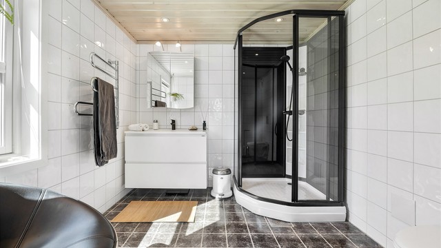 Badet i første etasje har fliser på gulv/vegger, gulvvarme og dusjkabinett.
