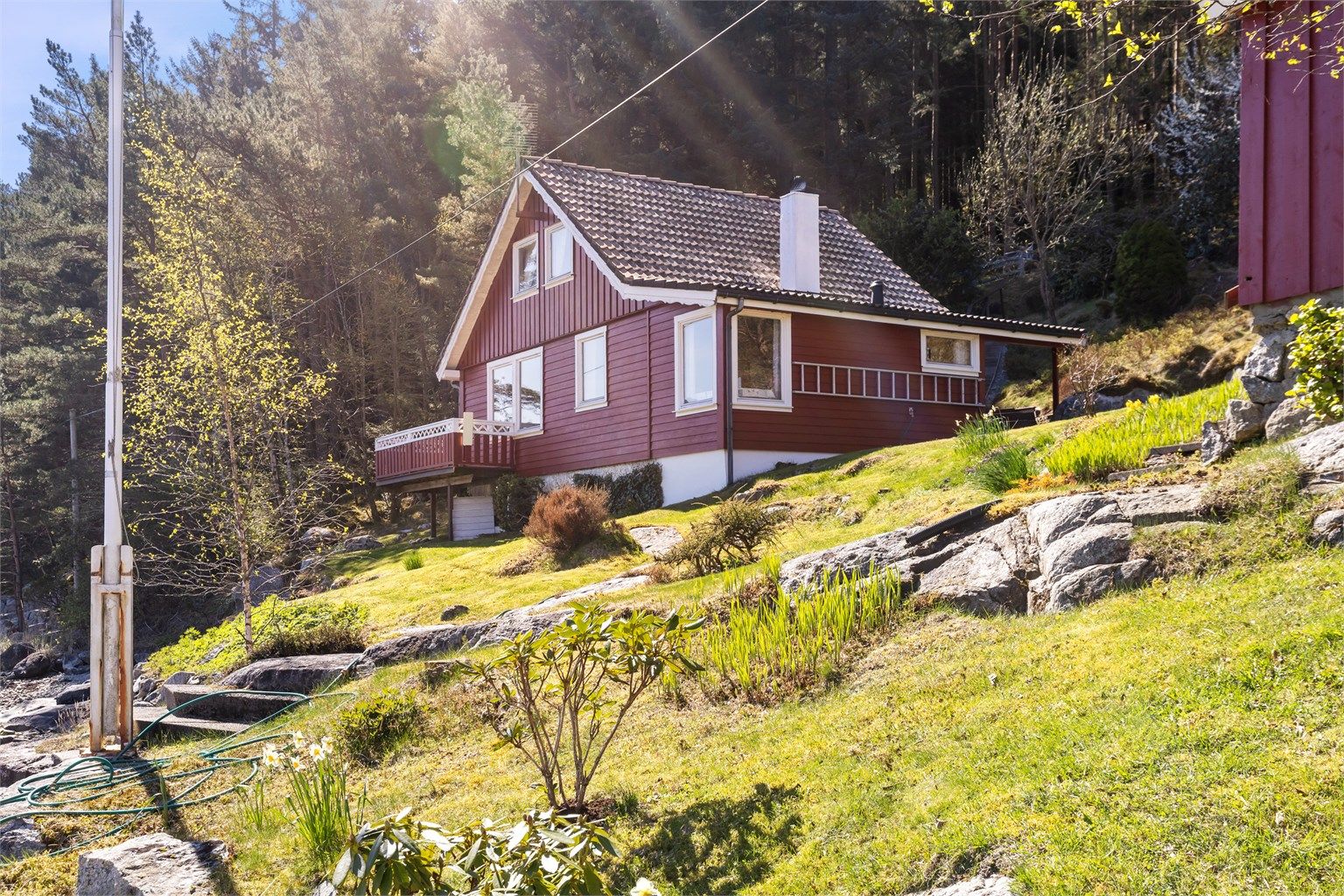 Eiendommen er omkranset av frodig vegetasjon og svaberg.
