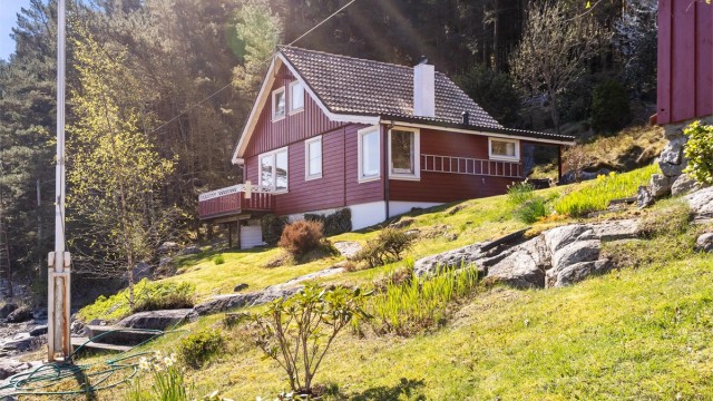 Eiendommen er omkranset av frodig vegetasjon og svaberg.