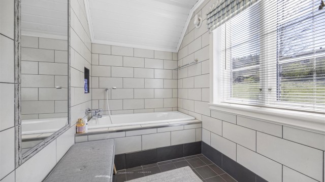 Bad 2 etasje utstyrt med badekar, servant og toalett.