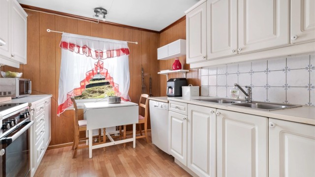 Kjøkkeninnredning er fra ukjent årstall med profilerte fronter og benkeplate med laminert overflate