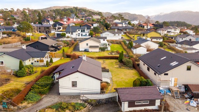 Asfaltert innkjørsel med biloppstillingsplass og garasje.