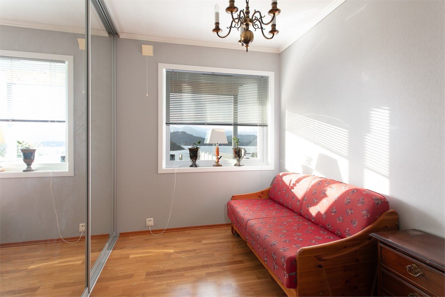 Soverom to har parkett på gulv og skyvedørsgarderobe med speilfronter.
