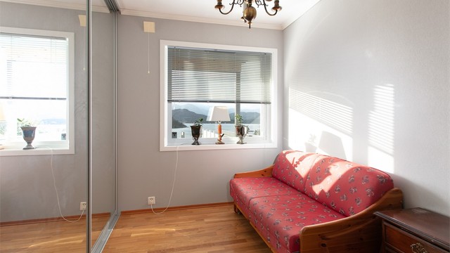 Soverom to har parkett på gulv og skyvedørsgarderobe med speilfronter.