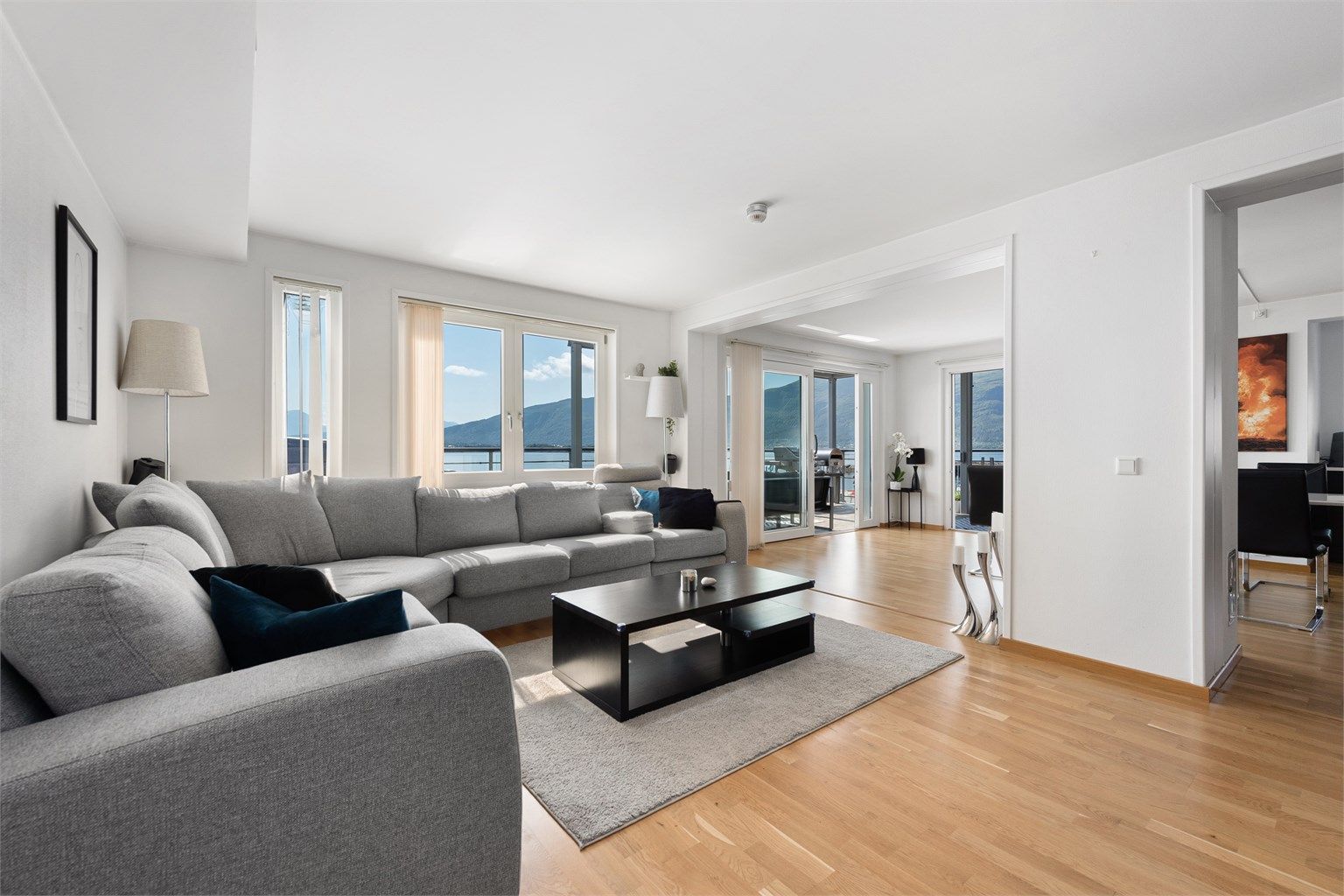 Stuen har lyse overflater og godt med naturlig lysinnslipp fra store vindusflater.