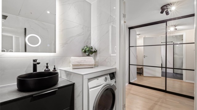 Badet har varme i gulvet, downlights i taket og opplegg for vaskemaskin.