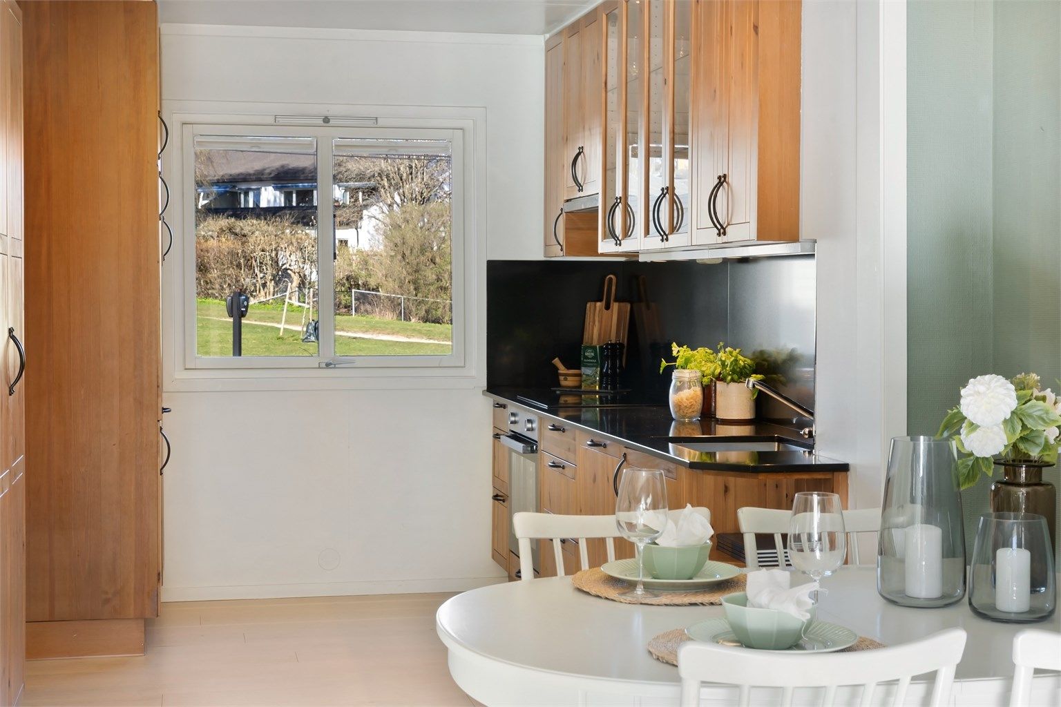 Det er plass til et lite spisebord på kjøkkenet, med utsikt mot grøntområdene ved Damefallet balløkke.