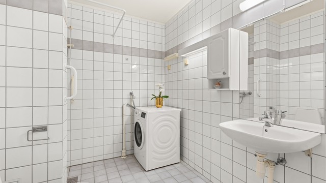 Stort flislagt bad med gulvvarme og opplegg for vaskemaskin.