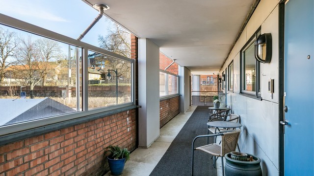 Svalgangen er godt skjermet fra vær og vind. Dette er fellesareal, men av flere seksjonseiere pent møblert med blant annet små sittegrupper.