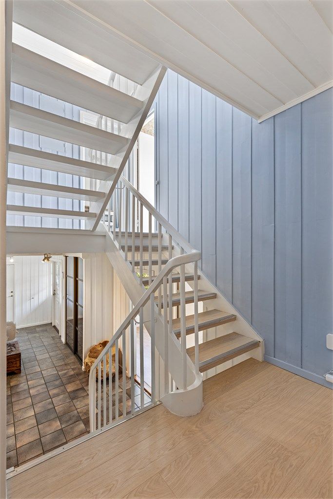 Fra halvplan to leder trappen videre ned til husets første etasje. Her finner du entré, gang, bad, soverom, vaskerom og bod.