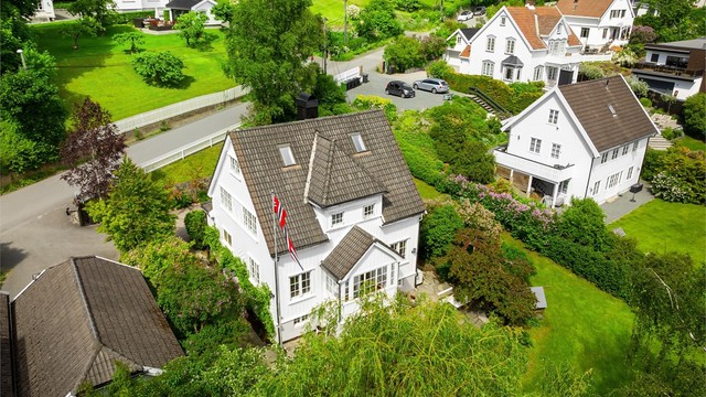 Oversikt over eiendommen med bolighus og garasje.