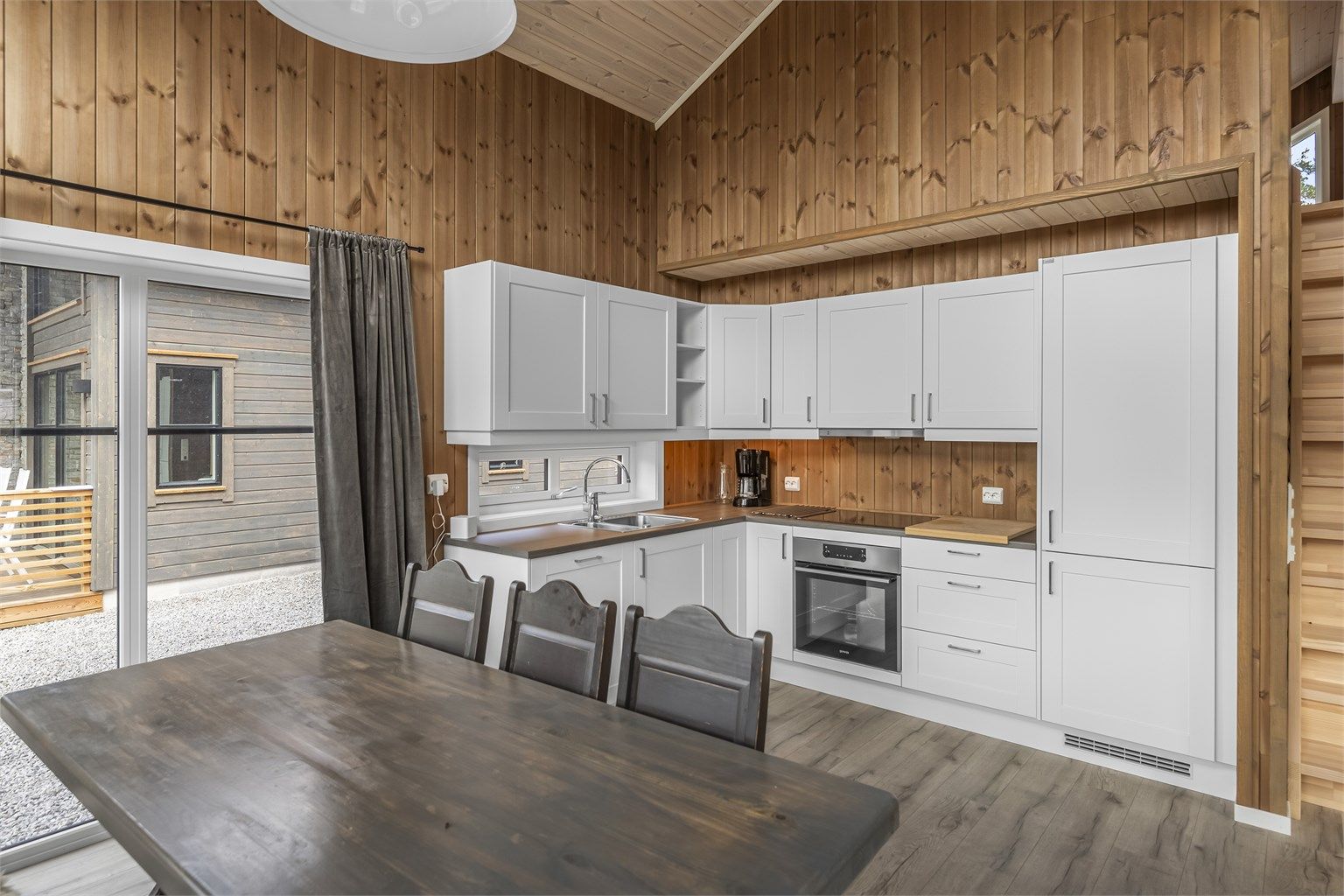 Kjøkkenet er innredet med hvitprofilerte fronter og med integrerte hvitevarer