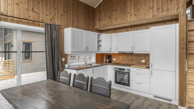 Kjøkkenet er innredet med hvitprofilerte fronter og med integrerte hvitevarer