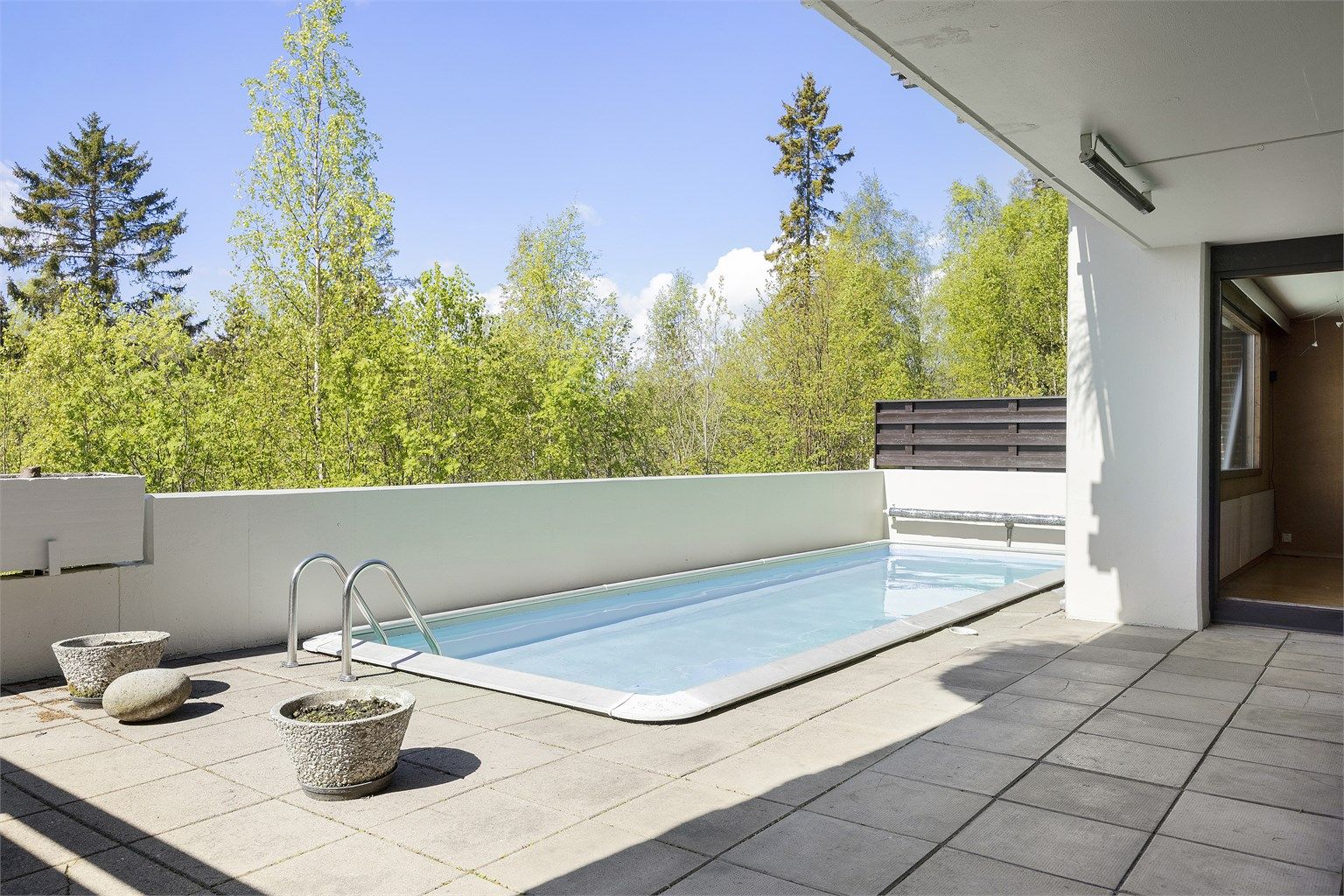 Utgang fra stue/soverom til vestvendt terrasse på 68 kvm. med svømmebasseng.