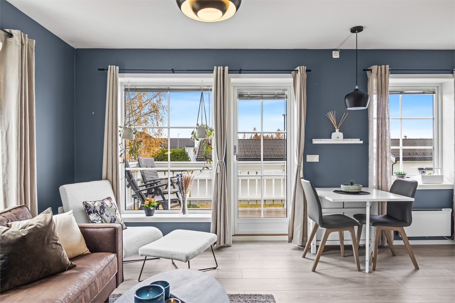 Store vinduer og glassdør knytter stuen sømløst sammen med uteplassen.