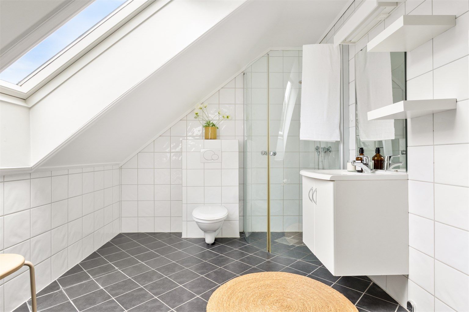 Badet på loftet har varmekabler, dusj og et stort takvindu som gir rikelig med dagslys.