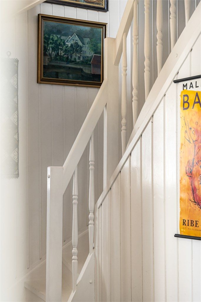 Trapperommet har panel på veggene og et rekkverk i tre som understreker boligens klassiske preg.