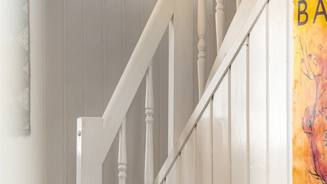 Trapperommet har panel på veggene og et rekkverk i tre som understreker boligens klassiske preg.