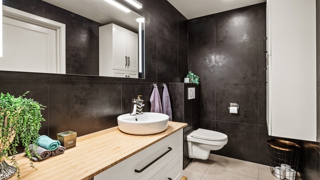 Badet er innredet med vegghengt toalett og en romslig servantinnredning.