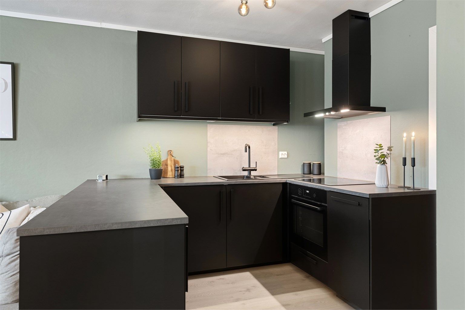 Kjøkkeninnredning fra 2019 med sorte glatte fronter og benkeplate av laminat. Integrert stekeovn, platetopp, oppvaskmaskin og kjøleskap med fryser. Vegghengt ventilator. 