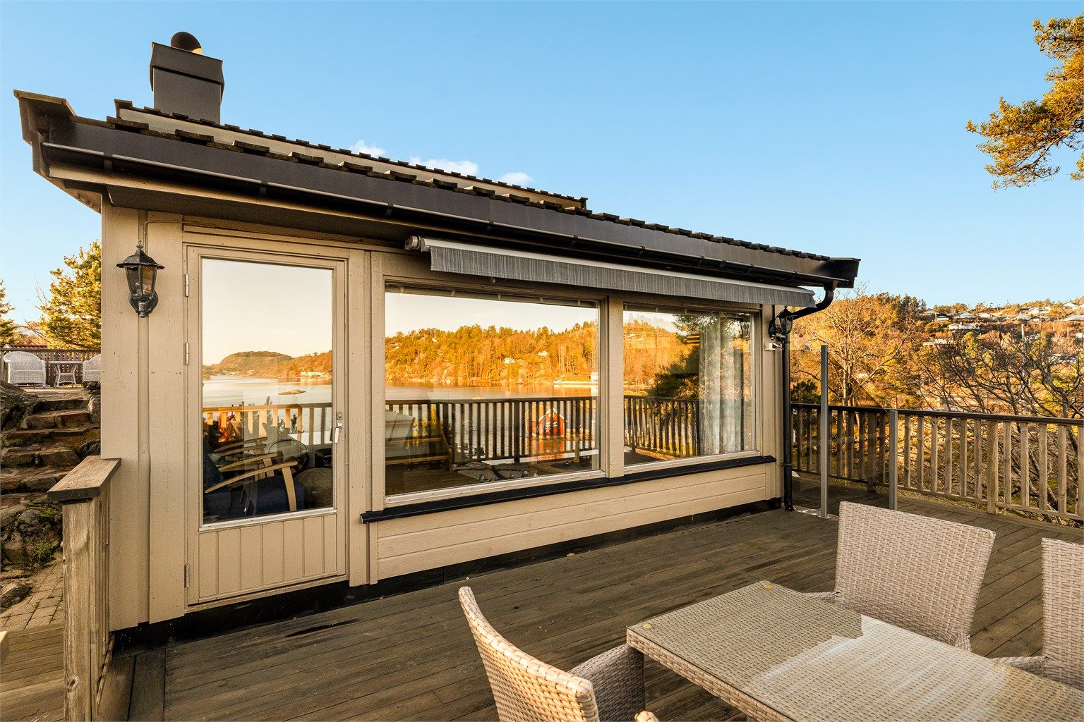 Store vindusflater i stua speiler utsikten en vakker høstdag.