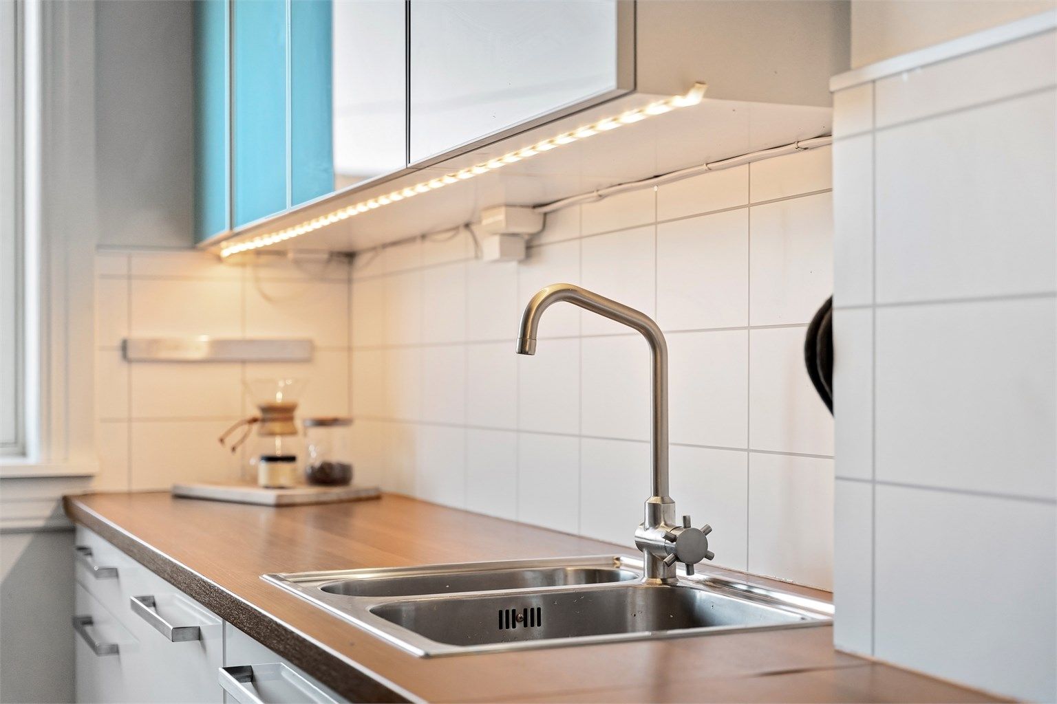 Kjøkkenet har glatte fronter, benkeplate med laminert overflate og laminerte plater over benken