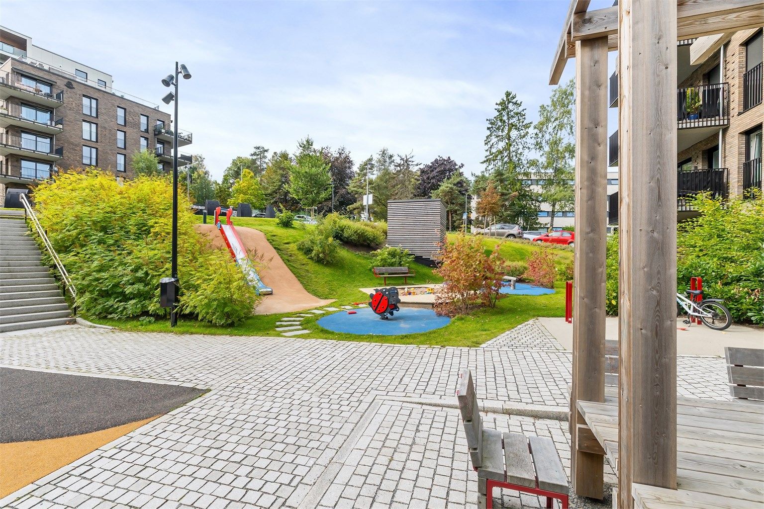 Skjermet fellesareal med pergola og sitteplasser. Borettslaget har også felles smørebod og sykkelrom med sykkeldusj.