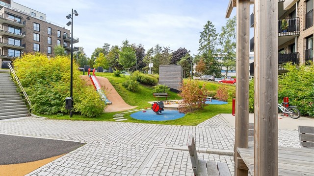 Skjermet fellesareal med pergola og sitteplasser. Borettslaget har også felles smørebod og sykkelrom med sykkeldusj.