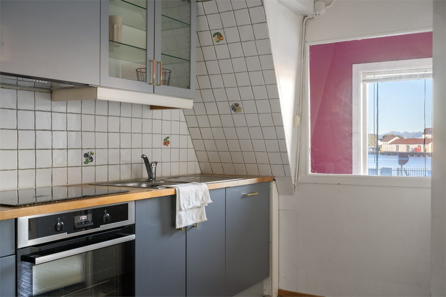 Vindu mot gateløpet slipper inn naturlig dagslys til kjøkkenbenken.