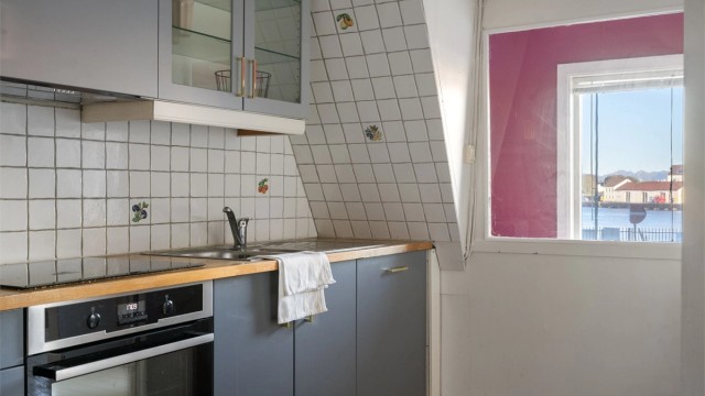 Vindu mot gateløpet slipper inn naturlig dagslys til kjøkkenbenken.