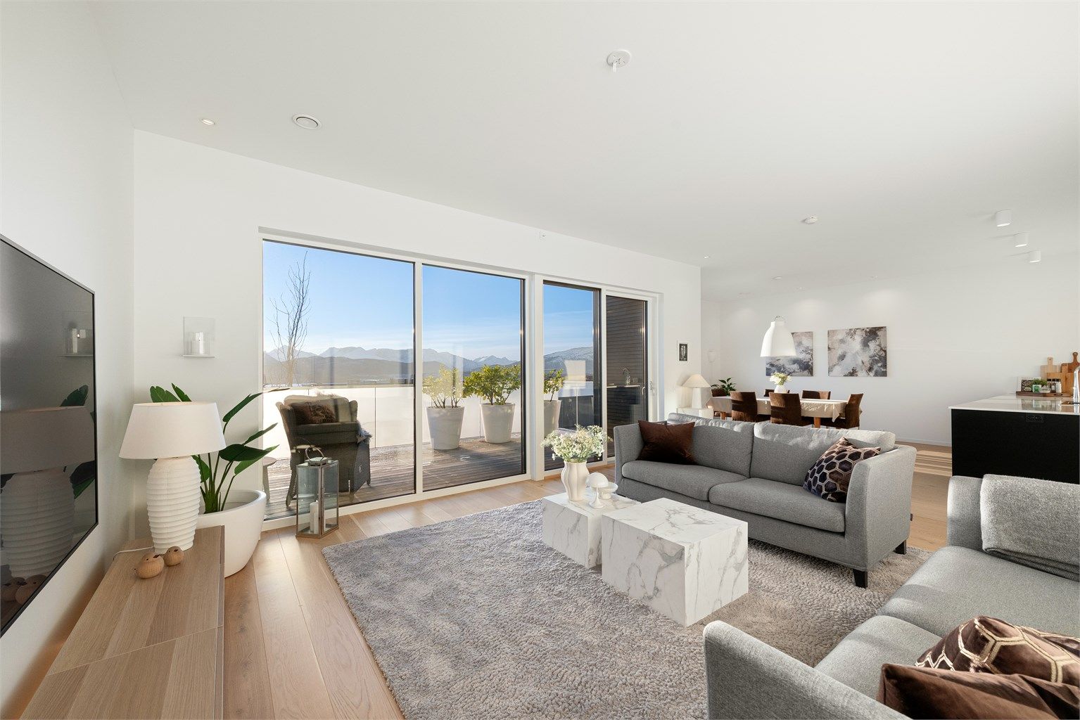 Stuen har stor skyvedør ut til balkong med glassrekkverk og nydelig utsikt