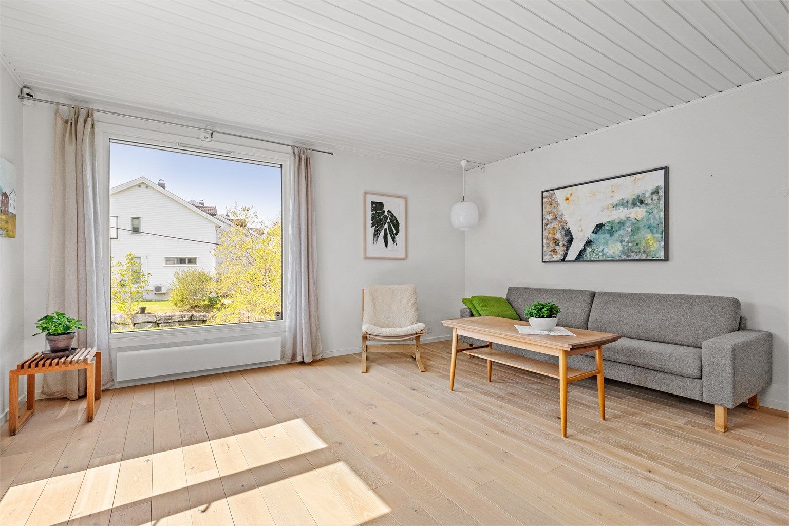De store vindusflatene gir mye naturlig lys inn til rommet og et fint utsyn mot hagen