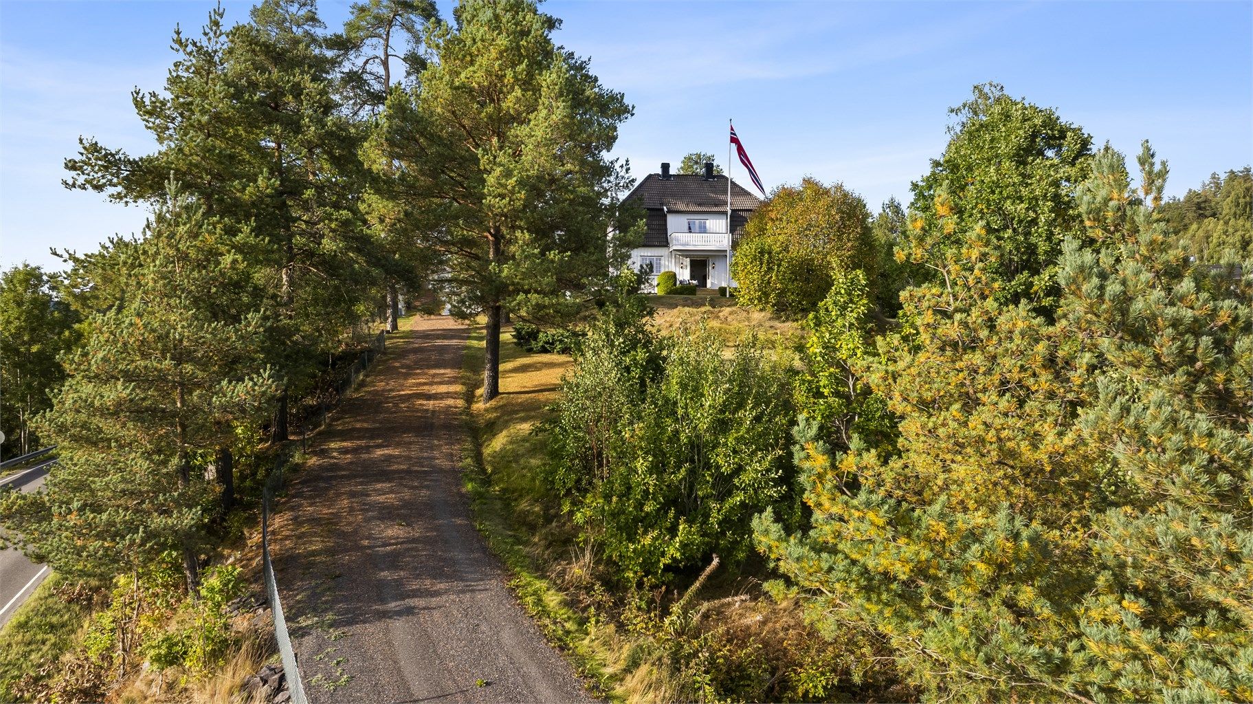 Klassisk gruset oppkjørsel til eiendommen som ligger fint plassert på en høyde!