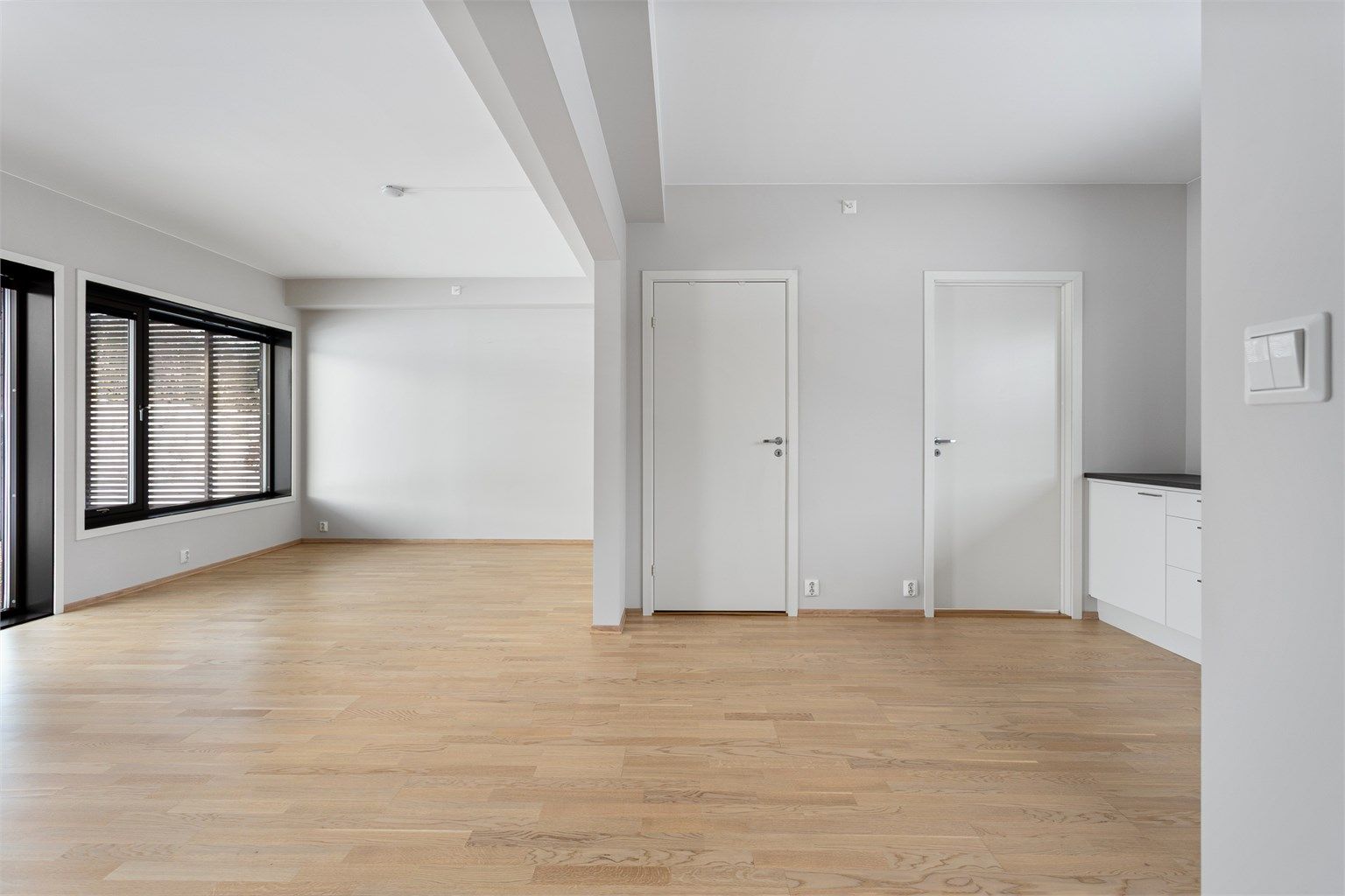 Lyse, malte veggflater og glatte innerdører gir et stilrent og moderne uttrykk.