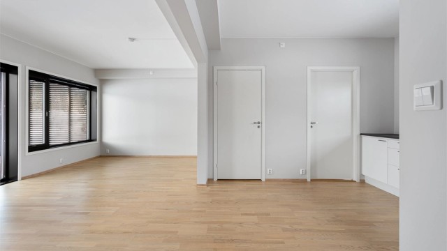 Lyse, malte veggflater og glatte innerdører gir et stilrent og moderne uttrykk.